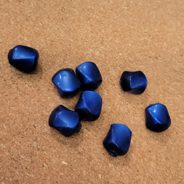 Eight deep blue vintage Lucite beads with rounded angular sides and bright blue highlights.
