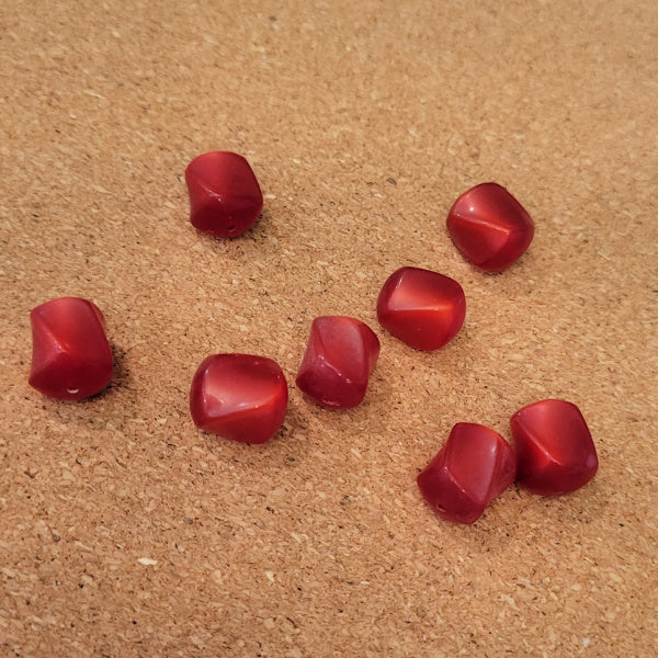 Eight red vintage Lucite beads with rounded angular sides and a luminous sheen.