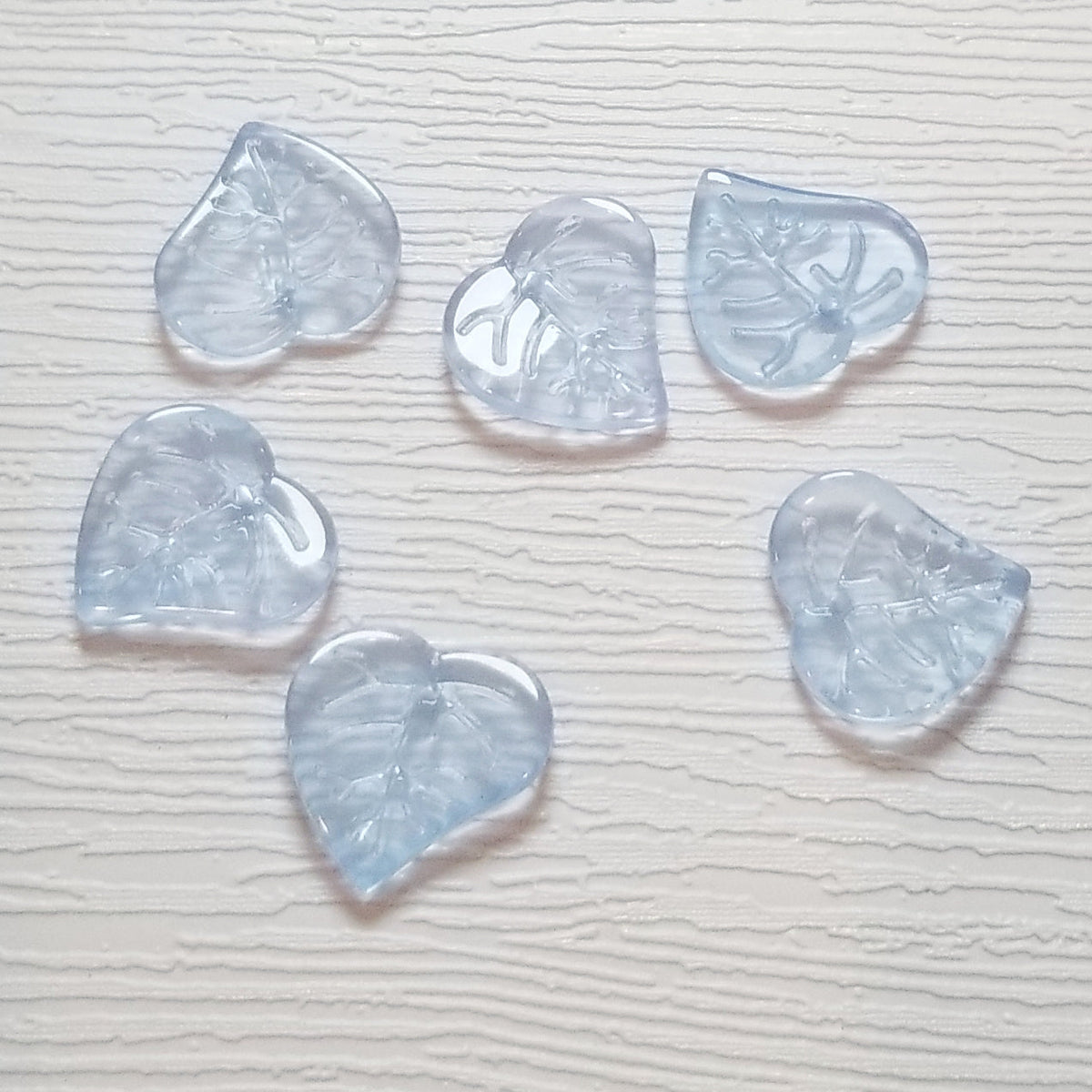 Ice blue premium glass leaf heart bead showing the top hole drilled front to back