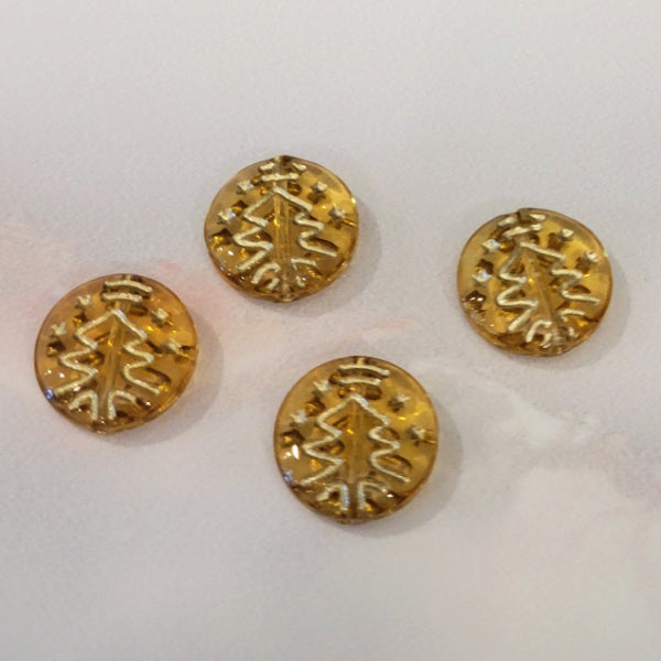Four transparent golden topaz Czech glass disc beads with metallic gold Christmas tree designs.