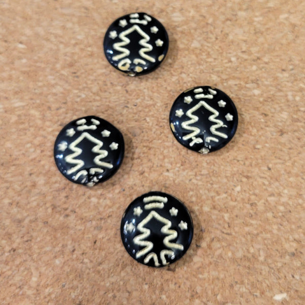 Four opaque black Czech glass disc beads with metallic gold Christmas tree designs.