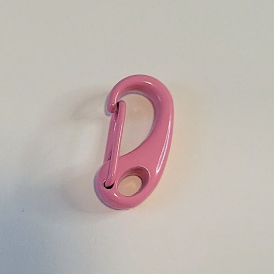 A glossy pink metal carabiner clip photographed on a plain off-white background.