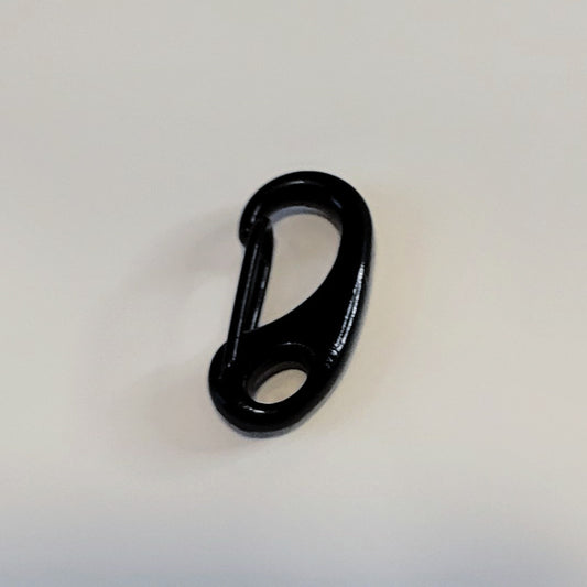 A glossy black carabiner clip photographed on a plain light background.