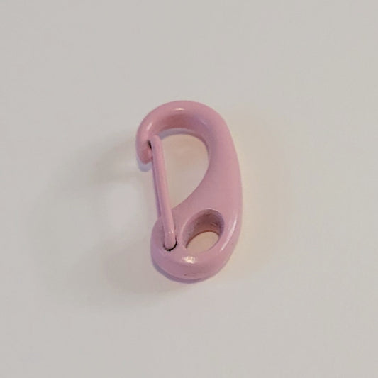A small glossy pink metal carabiner clip on a plain light gray background.