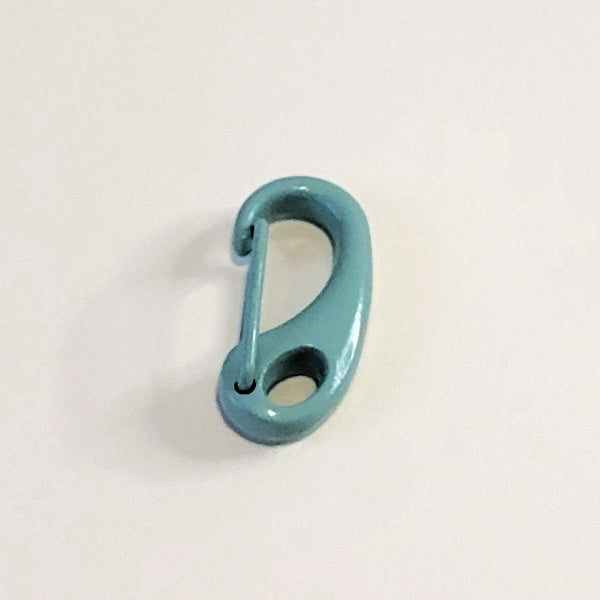 A small teal blue metal carabiner clip with a glossy finish, photographed on a plain off-white background.