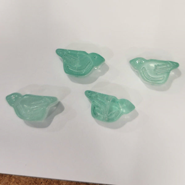 Four transparent aqua pressed glass bird beads