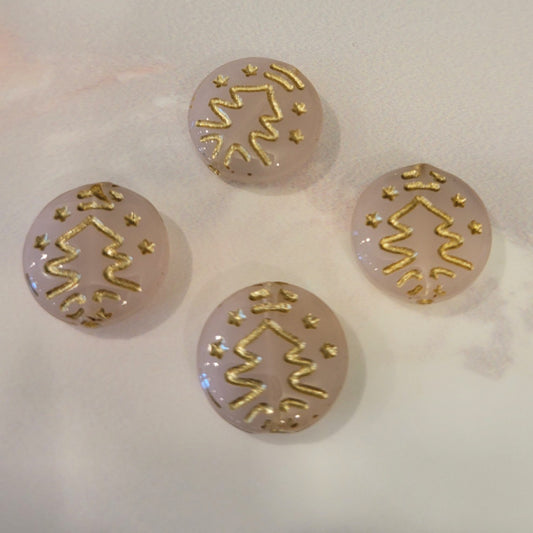 Four milky pink Czech glass disc beads with metallic gold Christmas tree designs.
