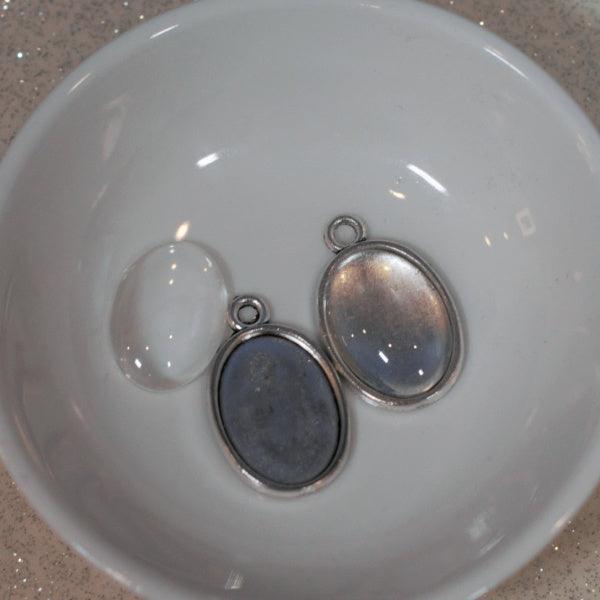 18 x 13 mm Tray pendants with glass cabochon. Silver tone metal. 